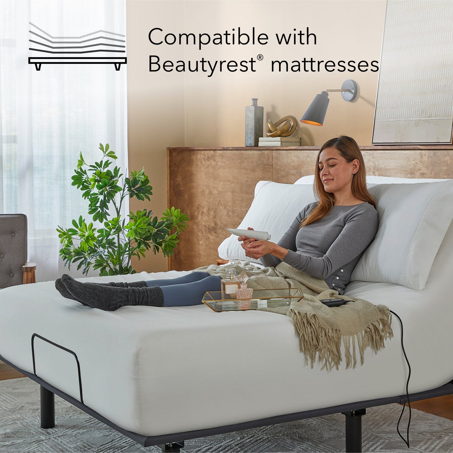 Woman sitting on a white mattress on a Bronze baselogic adjustable base
