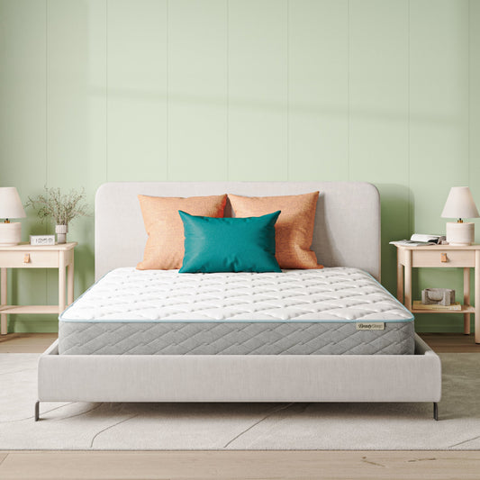 Beautysleep Mattress in a grey bedframe with 3 pillows on top of it within a bedroom setting